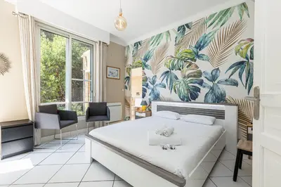 a bedroom with a bed with a tropical wallpaper at VILLA CRUG HYWEL - VILLEFRANCHE-SUR-MER in Villefranche-sur-Mer