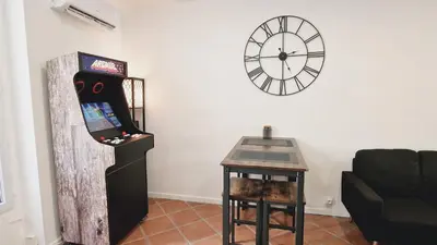 a room with a video game console and a clock at Loft Place Massena in Nice