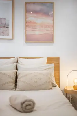 a bed with white sheets and pillows in a bedroom at Appartement bord de mer « La Petite Ma-Line » in Cagnes-sur-Mer