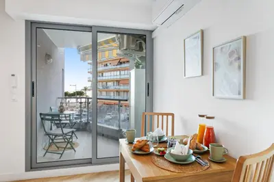 a dining room with a table and a balcony at Appartement bord de mer « La Petite Ma-Line » in Cagnes-sur-Mer