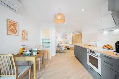 a kitchen and living room with a table and chairs at Appartement bord de mer « La Petite Ma-Line » in Cagnes-sur-Mer