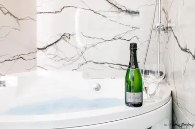 a bottle of wine sitting on top of a toilet in a bathroom at Nice Renting - FRANCE - Luxury Suite Palace Love Jacuzzi - Few meters from Sea in Nice