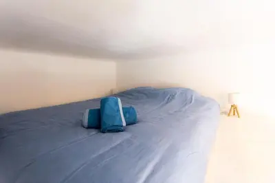 a large bed with blue sheets in a bedroom at #2 Central Studio top floor AC & Balcony in Nice