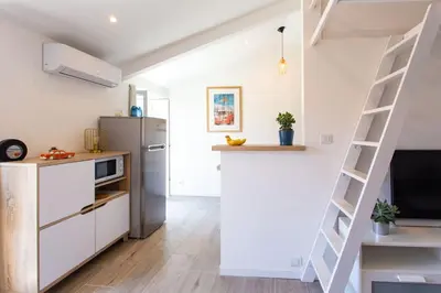 a kitchen with white cabinets and a ladder at #2 Central Studio top floor AC & Balcony in Nice