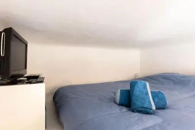 a bedroom with a bed with a flat screen tv at #2 Central Studio top floor AC & Balcony in Nice