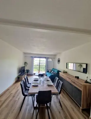 a dining room table with chairs and a wooden floor at Cagnes sur Mer-Spacieux 2 pièces in Cagnes-sur-Mer