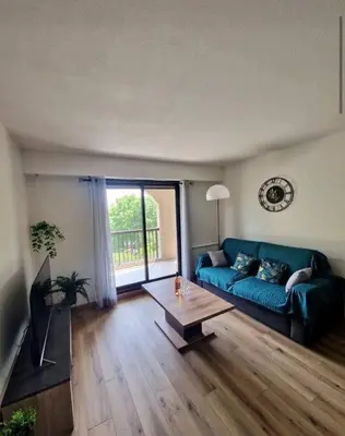 a living room with a blue couch and a table at Cagnes sur Mer-Spacieux 2 pièces in Cagnes-sur-Mer