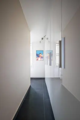 a hallway with white walls and a glass wall at Le balcon de la baie des Anges in Nice