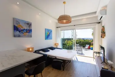 a living room with a table and a large window at #43 Design Studio Terrace AC Wifi Sea View 1min Beach in Nice