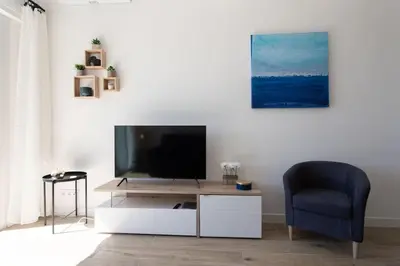 a living room with a tv and a blue chair at #43 Design Studio Terrace AC Wifi Sea View 1min Beach in Nice