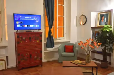 a living room with a television and a chair at Apartment 33 on The Old Historic Senate Square in Nice