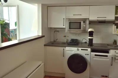 a kitchen with a washing machine and a microwave at Apartment 33 on The Old Historic Senate Square in Nice