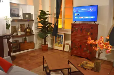 a living room with a tv and a table at Apartment 33 on The Old Historic Senate Square in Nice