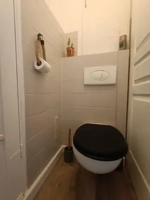 a small bathroom with a black and white toilet at F4 avec vue mer / Flat with sea view 3 bedrooms in Nice