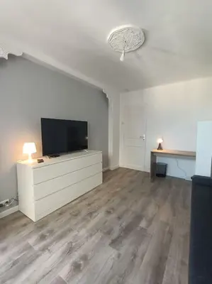 a living room with a flat screen tv on a dresser at F4 avec vue mer / Flat with sea view 3 bedrooms in Nice