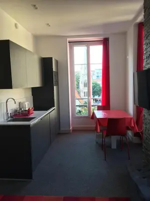 a kitchen with a red table and a window at Magnifique studio carré d’or in Nice