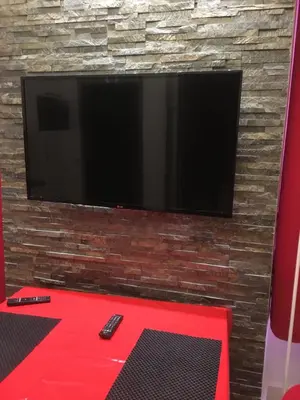 a flat screen tv mounted on a brick wall at Magnifique studio carré d’or in Nice