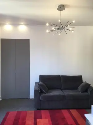 a living room with a couch and a chandelier at Magnifique studio carré d’or in Nice