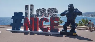 a statue of a man standing in front of a sign at Vue mer et montagne panoramique in Nice