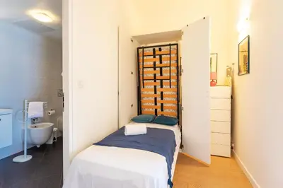 a small bedroom with a bed and a bathroom at LA RESERVE AP4369 By Riviera Holiday Homes in Villefranche-sur-Mer