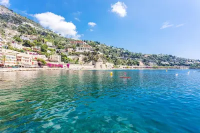 a view of a body of water with a beach at LA RESERVE AP4369 By Riviera Holiday Homes in Villefranche-sur-Mer