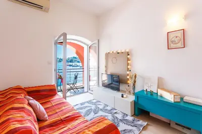 a bedroom with a bed and a tv and a window at LA RESERVE AP4369 By Riviera Holiday Homes in Villefranche-sur-Mer