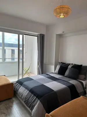 a bedroom with a large bed and a large window at Chambre promenade des anglais in Nice