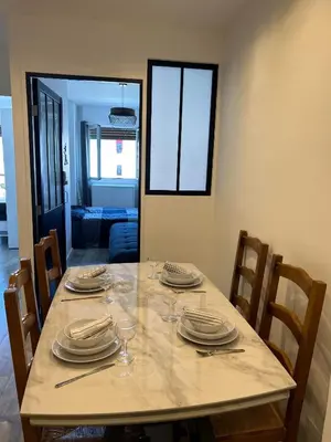 a dining room table with plates and glasses on it at Chambre promenade des anglais in Nice