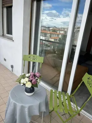 a table and two chairs and a vase of flowers on a balcony at Chambre promenade des anglais in Nice