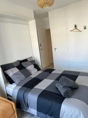 a bedroom with a bed with blue and white sheets at Chambre promenade des anglais in Nice
