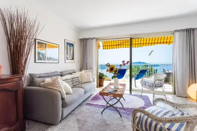 a living room with a couch and a view of the ocean at LE CALIFORNIA 3 AP4366 By Riviera Holiday Homes in Villefranche-sur-Mer