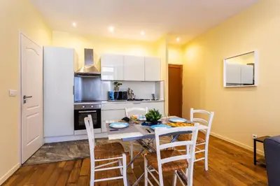 a kitchen and dining room with a table and chairs at LE ST FRANCOIS AP4368 By Riviera Holiday Homes in Nice