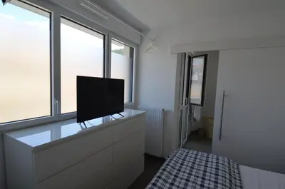 a room with a tv on a dresser with windows at VILLA SMOLETT - Appartement Cosy au cœur du quartier du port in Nice