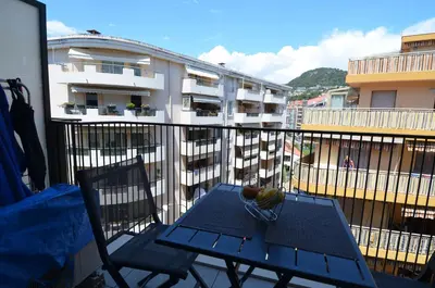 a balcony with a blue table and chairs and buildings at VILLA SMOLETT - Appartement Cosy au cœur du quartier du port in Nice