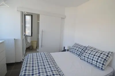a white bedroom with a bed with a checkered blanket at VILLA SMOLETT - Appartement Cosy au cœur du quartier du port in Nice