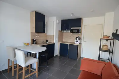a small kitchen with a table and chairs in a room at VILLA SMOLETT - Appartement Cosy au cœur du quartier du port in Nice