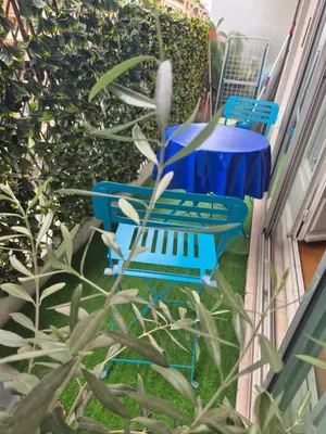 two blue chairs and a table in a garden at Le Grand Sud in Nice