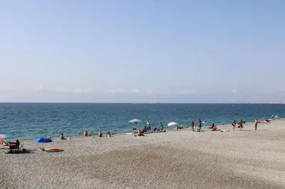 a group of people on a beach near the water at Le Grand Sud in Nice
