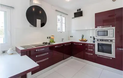 a kitchen with brown cabinets and a white counter top at Nice Home In Saint-Laurent-Du-Var in Saint-Laurent-du-Var