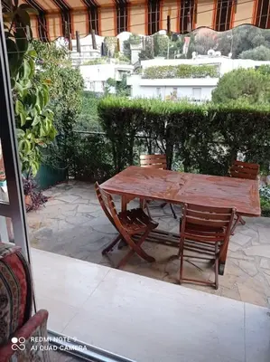 a wooden table and two chairs sitting around a table at Nice Fabron 90 m2 avec Garage in Nice