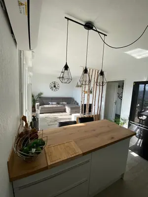 a kitchen with a wooden counter top and some lights at Studio cosy in Nice