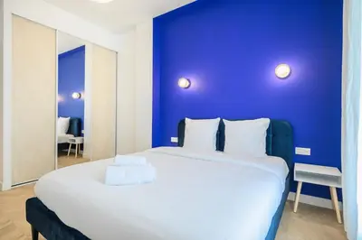 a bedroom with a large bed with a blue wall at Le Walesa, magnifique 3P, spacieux et rénové, Port de Nice in Nice