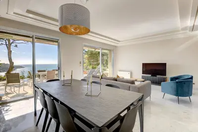 a dining room with a table and a couch at Giant Terrace on a stunning View in Villefranche-sur-Mer