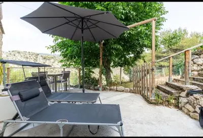 a patio with a chair and an umbrella at Domaine luna estella in Tourrette-Levens