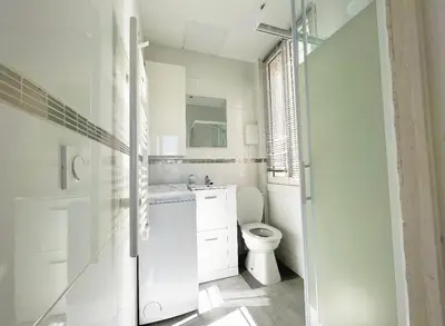 a white bathroom with a toilet and a sink at Cosy studio ensoleillé - centre-ville – TRAM/AC in Nice