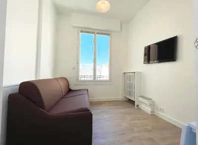 a living room with a couch and a television at Cosy studio ensoleillé - centre-ville – TRAM/AC in Nice