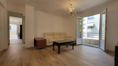 a living room with a couch and a table at appartement neuf de 3 pieces avec climatisation in Nice