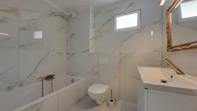 a white bathroom with a toilet and a sink at appartement neuf de 3 pieces avec climatisation in Nice