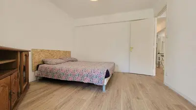 a bedroom with a bed and a dresser at appartement neuf de 3 pieces avec climatisation in Nice