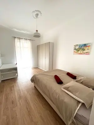 a bedroom with a bed with red pillows on it at Large Haussmanian appartment in the heart of Nice in Nice